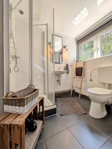a bathroom with a toilet and a shower and a sink at Ferienwohnung im Loftstil in Hemmoor