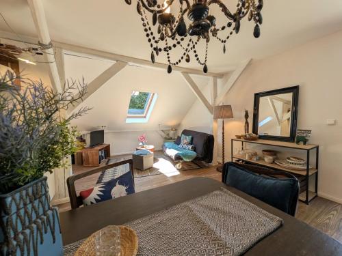 a living room with a dining table and a chandelier at Ferienwohnung im Loftstil in Hemmoor