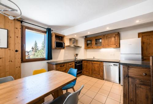 a kitchen with wooden cabinets and a table and chairs at Résidence Geffriand - Triplex pour 10 personnes proche des pistes au coeur des 3 Vallées MAE-4944 in Levassaix