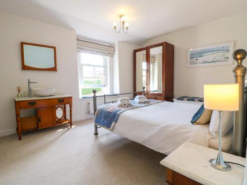 a bedroom with a bed and a table and a lamp at Sunnyside in Matlock