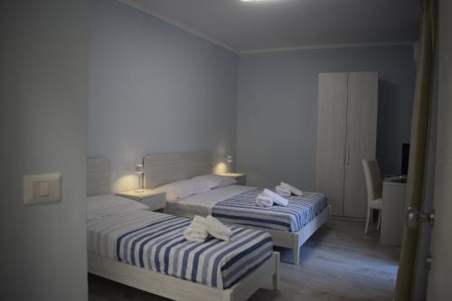 two beds in a hotel room with towels on them at B&B Nonna Matilde in Sapri