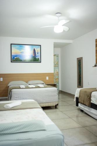 a room with four beds and a painting on the wall at Di Villa Búzios in Búzios