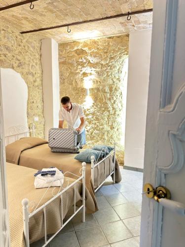 a man sitting on a bed using a laptop at B&B Don Nicola in Bonefro