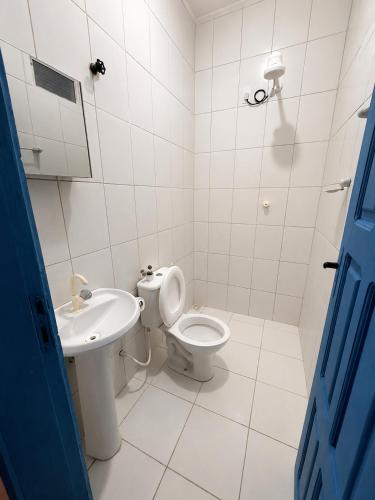 a white bathroom with a toilet and a sink at Pousada Flor de Sal in Prea