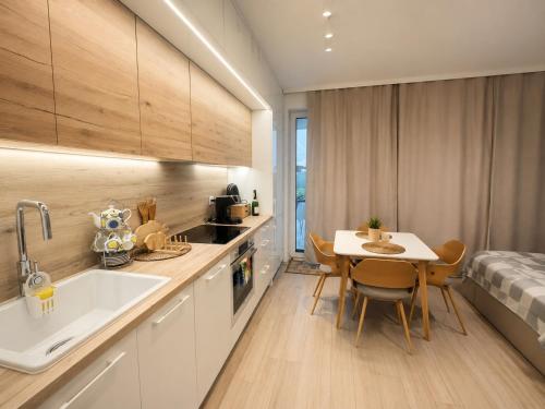 a kitchen with a table and a dining room at Augustowskie Apartamenty Blisko Jezior i Lasów oraz Bezpłatny parking in Augustów