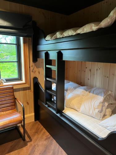 a bedroom with two bunk beds and a chair at Trudvang in Tänndalen