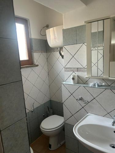 a small bathroom with a toilet and a sink at Ferienhaus Casa Silenzio in Mandatoriccio