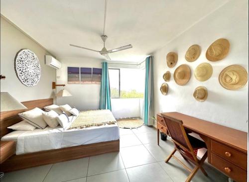 a bedroom with a bed and a desk in it at Blue Zebra - Seaview Sunset Apartment 1 in Tamarin