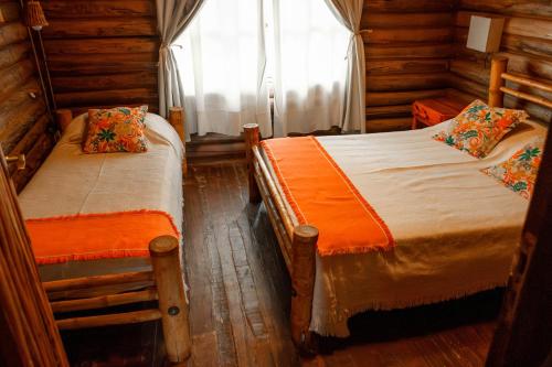 a bedroom with two beds in a log cabin at Cabañas Bella Vista in Bella Vista