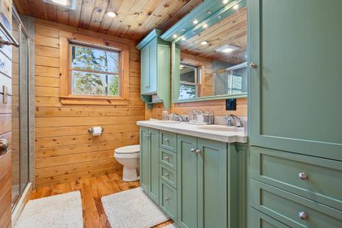 a bathroom with green cabinets and a sink and a toilet at Pleasant View in Island Falls