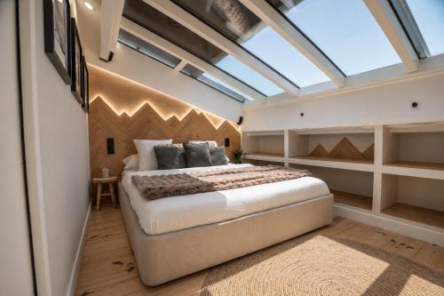 a bedroom with a large bed and a skylight at La Verriere & Le refuge in Foix