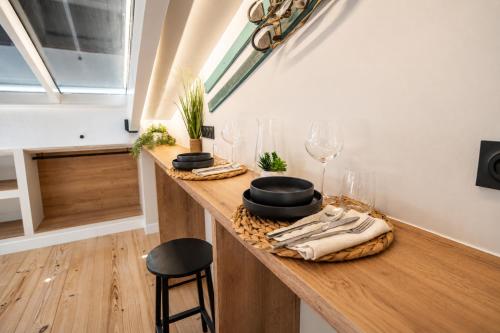 a room with a counter with wine glasses and a window at La Verriere & Le refuge in Foix