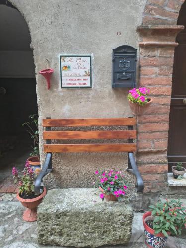 a wooden bench sitting next to a wall with flowers at A casa di Rita in Dunarobba