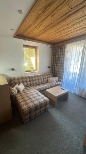 a living room with a couch and a coffee table at Hotel Kukučka Apartament Janka C105 Tatranská Lomnica in Vysoké Tatry