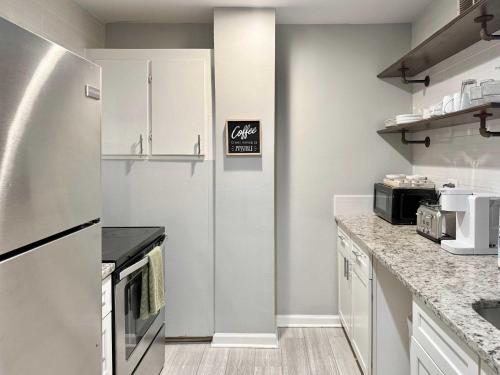 a kitchen with white cabinets and a refrigerator at Downtown Condo! Private Balcony! PT10F in Atlanta