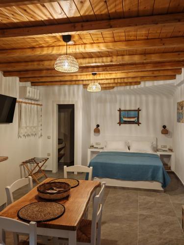 a bedroom with a bed and a table and chairs at Troulou beach house in Kimolos