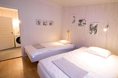 two beds in a room with white walls at Little Paradise in Morfjorden