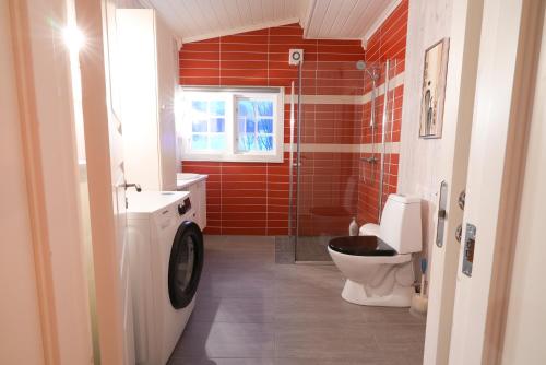 a bathroom with a toilet and a glass shower at Little Paradise in Morfjorden