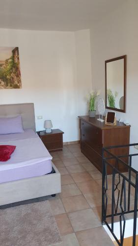 a bedroom with a bed and a dresser with a mirror at Ferienhaus Casa Silenzio in Mandatoriccio