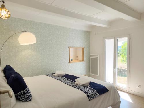 a bedroom with a large bed with a window at La Salagnac in Corrèze