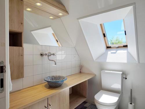 a bathroom with a toilet and a sink and a window at La Salagnac in Corrèze