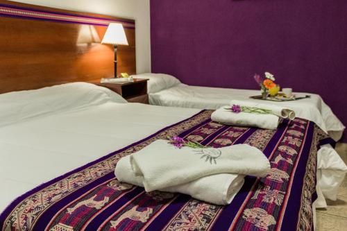 a hotel room with two beds with towels on them at Inti Masi in Salta