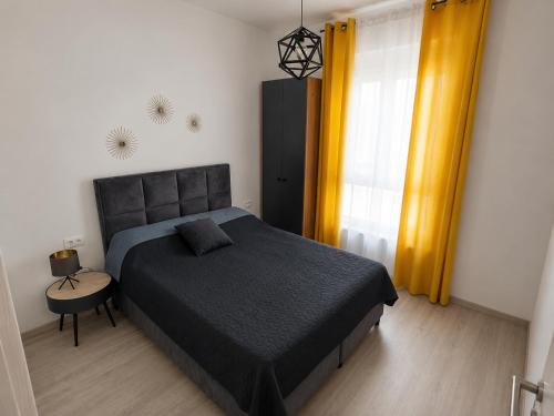 a bedroom with a large bed and yellow curtains at LouAdria Apartments in Đenovići