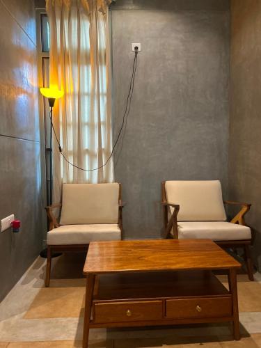 a living room with two chairs and a table at Savana Luxury Stay in Pondicherry
