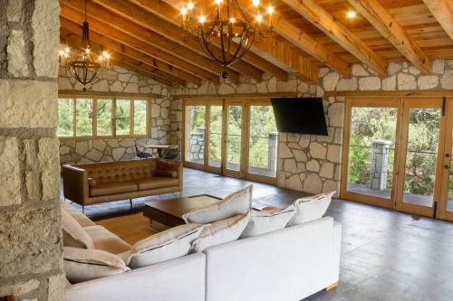 a living room with a white couch and a tv at Finca en el Bosque Huasca de Ocampo con Alberca in Huasca de Ocampo