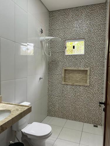a bathroom with a shower with a toilet and a sink at Vila da Andrea in Barreirinhas