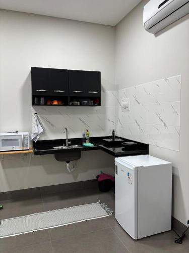 a kitchen with a sink and a refrigerator at Apartamento casa da Lu 102 in Primavera do Leste