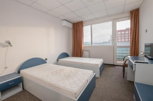 a hospital room with two beds and a window at Rhodopi Hotel Plovdiv in Plovdiv