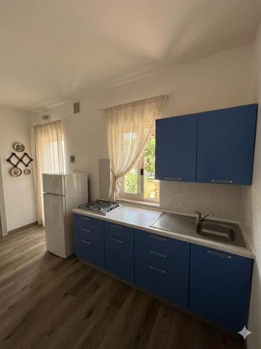 a kitchen with blue cabinets and a white refrigerator at De Sio Country Village in Peschici