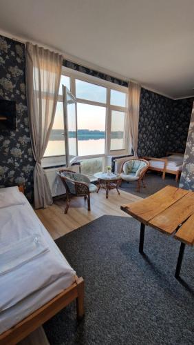 ein Schlafzimmer mit einem Bett und einem großen Fenster in der Unterkunft Na Molo in Głębokie