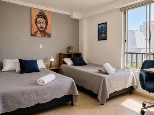 a room with two beds with a painting on the wall at Coliving Compostela in Medellín