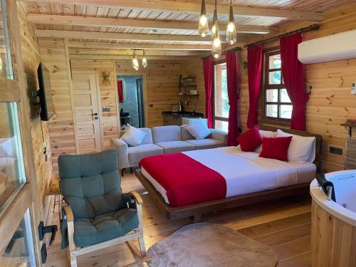 a bedroom with a bed and a couch and chair at Derya Dağ Evleri in Çamlıhemşin