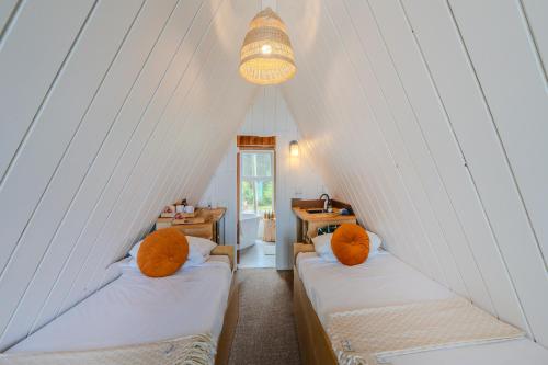 a room with two beds with orange pillows at The Shoreline Tofino in Tofino