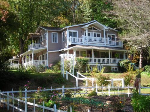 a large house with a white fence in front of it at Folkestone Inn in Bryson City