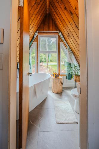 a bathroom with a large tub and a wooden ceiling at The Shoreline Tofino in Tofino