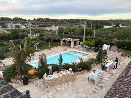 an overhead view of a pool with people standing around it at Casolare Lodedo in Ceglie Messapica