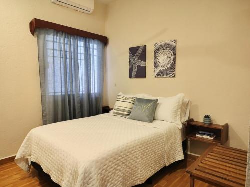 a bedroom with a white bed and a window at Comfortable apartment close to beaches and plazas in Santa Cruz Huatulco