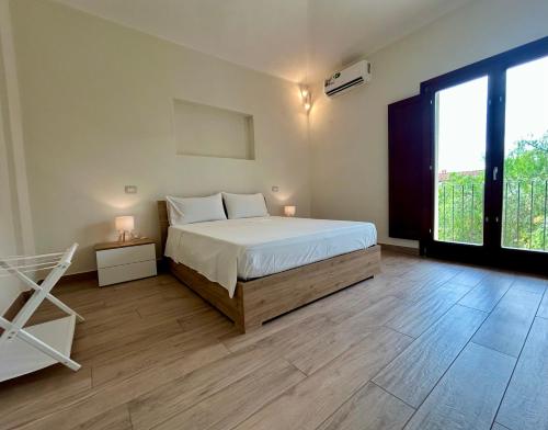 a bedroom with a bed and a large window at Casa Tanca Marchese in Marrùbiu