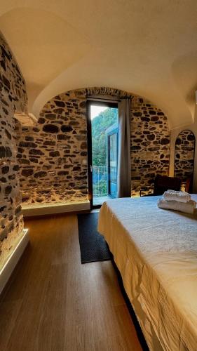 a bedroom with a large bed and a window at Nervia Rooms by Talking Stones in Dolceacqua