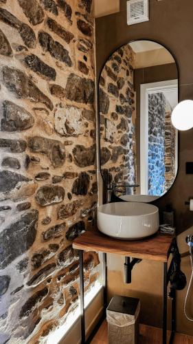 a stone bathroom with a sink and a mirror at Nervia Rooms by Talking Stones in Dolceacqua