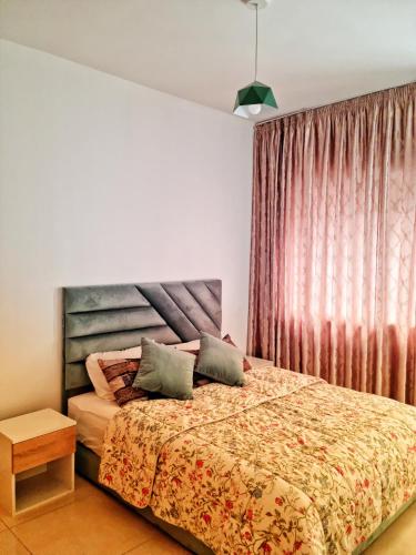 a bedroom with a bed with a wooden headboard at Cozy apartment adana in Aourir