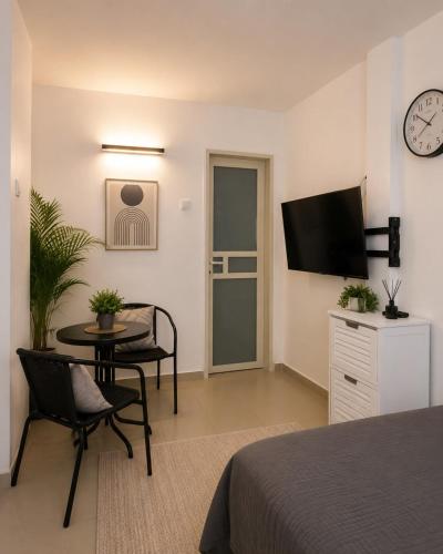 a room with a bed and a table and a tv at יחידת נופש בעמק המעינות in Bet Sheʼan