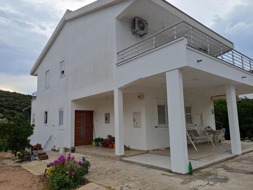 a white house with a porch and a balcony at Apartments Ivana in Ulcinj