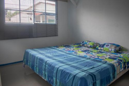 a bed with a blue comforter in a bedroom at Cozy Apartment in Minca in Minca