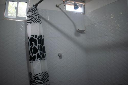 a shower with a black and white shower curtain at Cozy Apartment in Minca in Minca