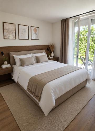 a large white bed in a bedroom with a window at Apartmani Stupe in Livno